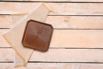 Stylish plate and napkin on light wooden background