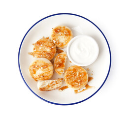 Plate with tasty cottage cheese pancakes and sour cream isolated on white background