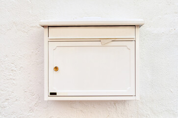 View of mailbox on white building wall
