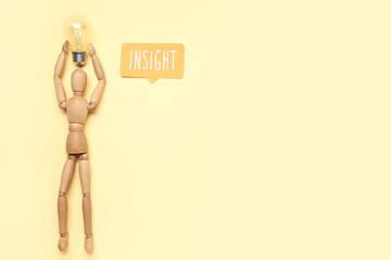 Wooden mannequin with light bulb and word INSIGHT on beige background