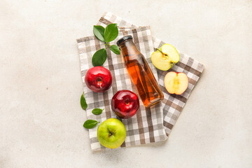 Glass bottle of fresh apple cider vinegar and fruits on white table