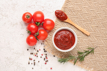 Napkin with bowl and spoon of tasty tomato paste on white grunge background