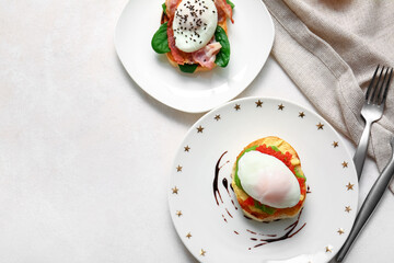 Plates with tasty eggs Benedict on white table