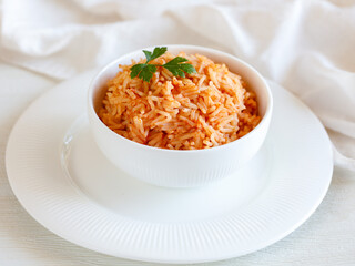 Tomato onion rice, Tamatar Biryani, jollof in white bowl on a white wooden table, horizontal