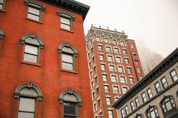  skyscraper's towering structure and old-fashioned architecture. multiple stories, with numerous rows of brickwork stacked upon each other to form its exterior walls. The bricks are weathered and worn