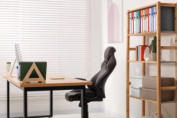 Desk and comfortable chair in modern office. Interior design