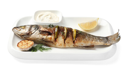 Plate with delicious baked sea bass fish, garlic, slice of lemon and sauce on white background