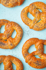 Tasty pretzels with poppy seeds on color background, closeup