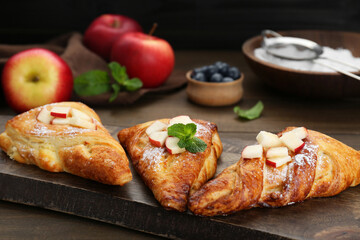 Fresh tasty puff pastry with apples and mint served on wooden table, closeup