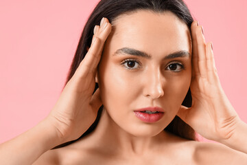 Naklejka premium Pretty young woman with healthy skin on pink background
