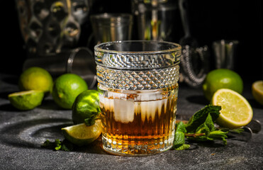 Fototapeta Glass of rum with ice, mint and lime on dark table obraz
