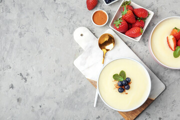 Bowls of tasty semolina porridge with strawberry and blueberry on grunge background