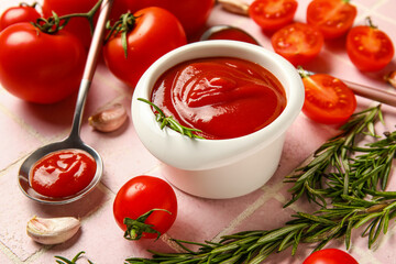Bowl with tasty ketchup and fresh tomatoes on pink tile background, closeup