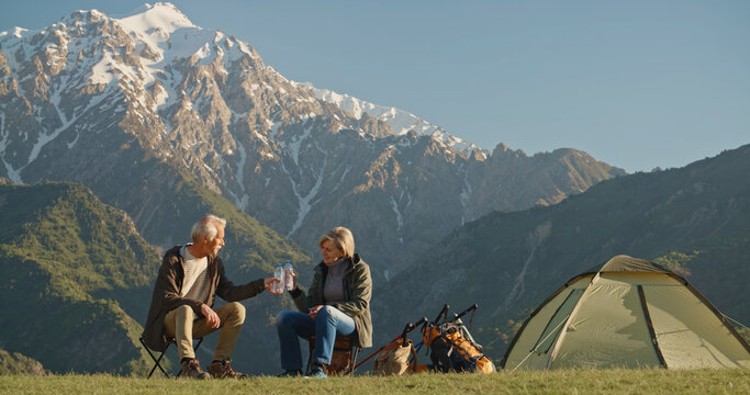 Two Happy Active Seniors Together Having Fun At The Top Of The Mountain In Evening Afternoon - Couple Of Mature People Enjoying And Having Fun In Vacations - Traveling And Travelers Lifestyle