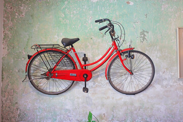 Red bicycle putting on the dirty and artisty wall