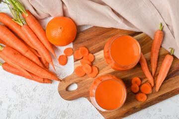 Fototapeta Two glasses of fresh carrot juice and orange on white grunge background obraz