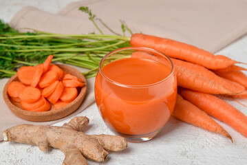 Fototapeta Two glasses of fresh carrot juice and ginger on white grunge background obraz