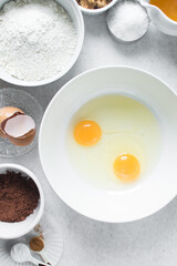 Organic raw eggs in a white mixing bowl for baking and cooking