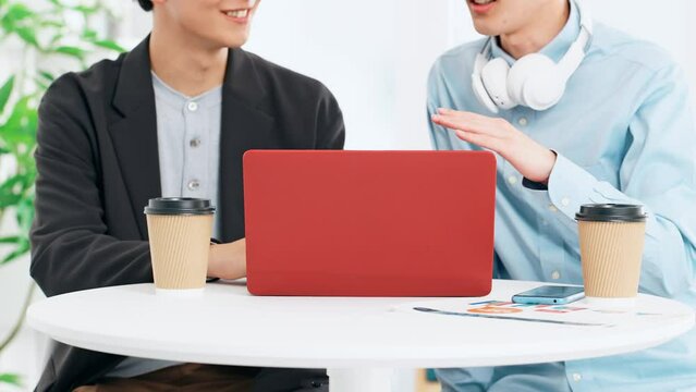 ノートパソコンを見る二人の若い男性