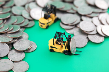 Two forklifts are sorting out a pile of coins