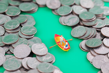 Miniature creative boat cruising among coins