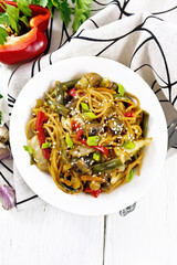 Spaghetti buckwheat with vegetables in plate on light board top