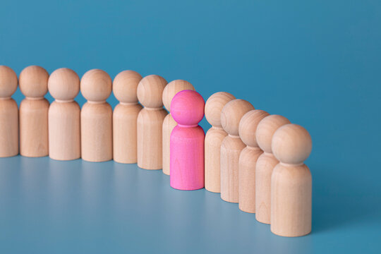 Make the difference, be yourself, against to the rule, think different, be brave, one in a million concept. wooden figures one of them in pink simulate a woman.