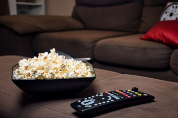 Popcorn near a remote. Generative AI