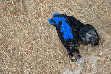 Fins for swimming and a mask for snorkeling on the beach. Wave and sand. Marine entertainment. Rest.