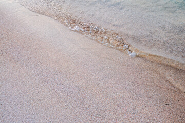 Soft wave of the sea on the sandy beach.