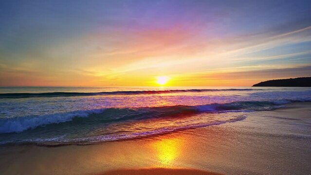 Golden sunset on a beach with crashing waves of foamy waves rolling towards colorful light sunset over sand beach,Beautiful view sunset or sunrise over sea,Ocean waves crashing on beach,Colorful sky