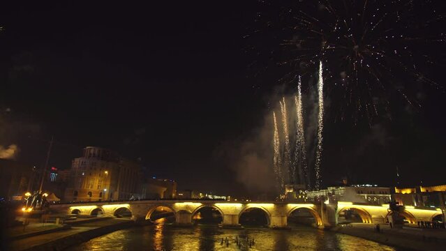 Firework show during new year eve celebration with reflection on Vardar river in Skopje, Macedonia