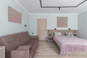 Hotel room with a large double bed in light colors