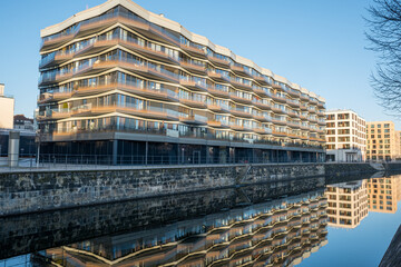 New apartment buildings in Berlin with a reflection in a small canal