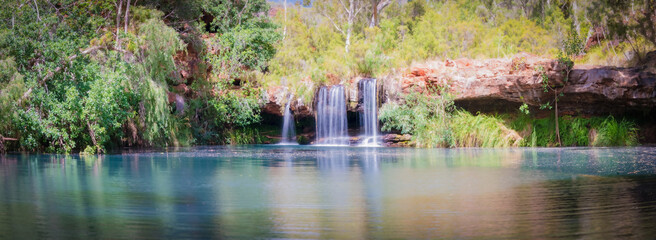 Panoramic view of an idyllic waterfall on a bright sunny day