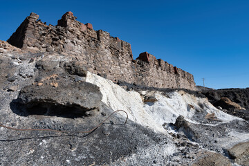 Old brick walls and mounds of mine tailings and on the path leading to the old mine site where BHP was founded in Broken Hill, New South Wales, Australia.