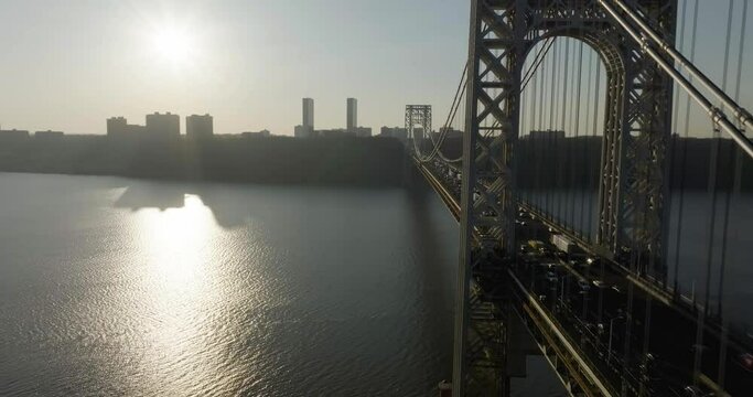Aerial view flying paralell to the George Washington bridge, sunset above Jersey, USA - reverse, drone shot