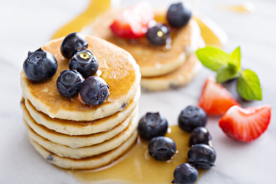 Stack of small pancakes with fresh berries