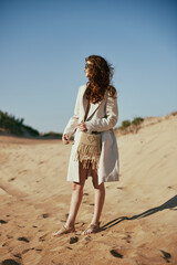 a slender woman in a light long jacket, in black glasses, with a bag slung over her shoulder,...