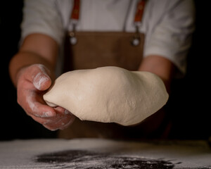 Cheef showing the dough to prepare his handmade pizza.