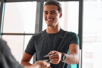 Credit card, man smile and payment at gym for fitness membership or exercise subscription. Fintech pos, ecommerce and happy athlete buying or paying for workout or training bill at exercising club.