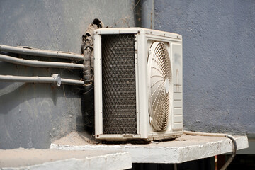Air conditioner exhaust unit. Old AC system installed in the exterior of the house building.