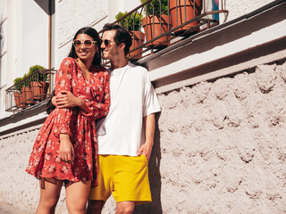 Smiling beautiful woman and her handsome boyfriend. Happy cheerful family. Sexy couple posing in the street at sunrise. During romantic date at sunny summer day outdoors. Looking at each other