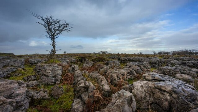 Timelapse of rural nature farmland with field ground rocks in the foreground during cloudy day viewed from Carrowkeel in county Sligo in Ireland.