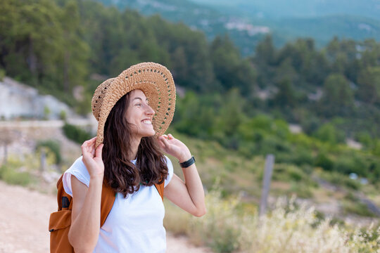 young girl in a straw hat and a backpack.