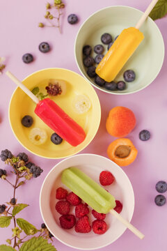 Colorful popsicles in bowls close up