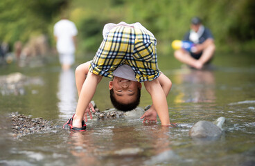 メインビジュアルにも！休みの日などに川で遊ぶ子供　夏のレジャーイメージに