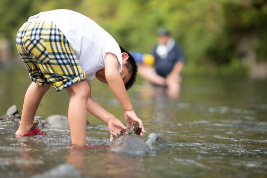 休みの日などに川で遊ぶ子供　夏のレジャーイメージに