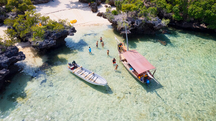 The tropical paradise of Zanzibar comes to life in this aerial view of fishing boats resting on the...