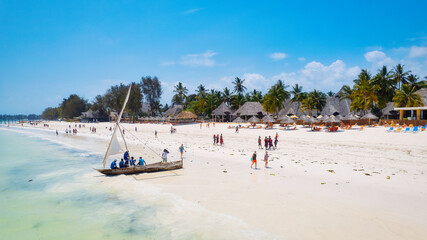 Take in the breathtaking beauty of Zanzibar's tropical coastline from above, as fishing boats dot...
